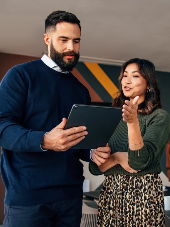 two businesspeople using a digital tablet in a boardroom two businesspeople using a digital tablet in a boardroom
